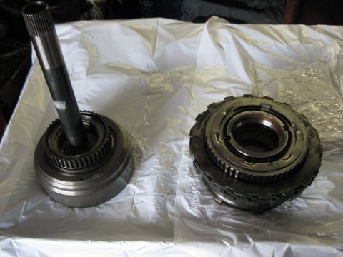 1994 Ford Bronco - Two disassembled transmission parts are laid out on a white surface.