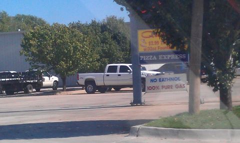 1965 Ford Mustang - A white pickup truck is parked on the side of the road near a Pizza Express establishment.