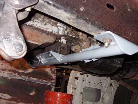 1967 Ford F-250 - A close-up shot of the undercarriage of a truck, focusing on the transmission and a newly installed support bracket.