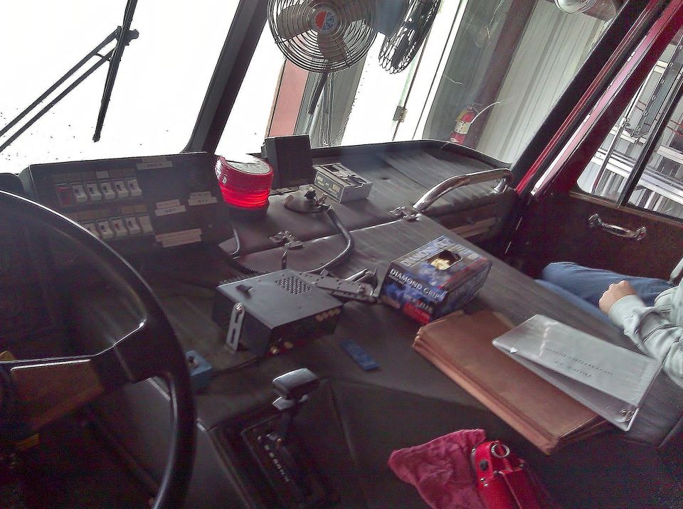 Dashboard of a vehicle with a steering wheel, various switches, a red light, and a box of tissues