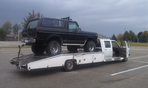 1979 Ford Bronco - A black 1978 Ford Bronco is transported on a white car carrier truck.