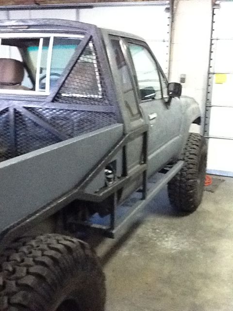 1988 Suzuki Samurai - This modified pickup truck features a custom bed and roll cage, likely a Toyota Hilux from the late 1980s.