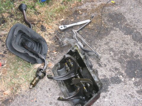 1981 Ford Bronco - Disassembled transmission shifter components and tools are laid out on the ground.