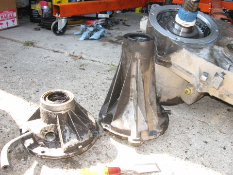 1981 Ford Bronco - Transmission components are laid out on a concrete surface, possibly for repair or replacement.