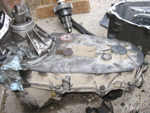1981 Ford Bronco - Transfer case and associated gears are laid out on a concrete surface, possibly for repair or replacement.