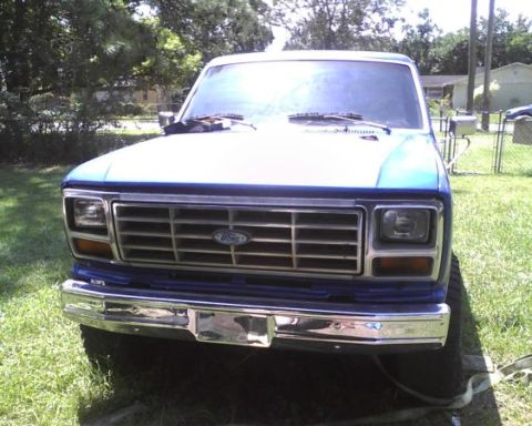 1985 Ford Bronco - Front view of a blue Ford truck, likely from the early 1980s, with a prominent chrome grille.