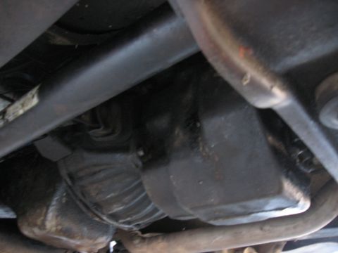 1981 Ford Bronco - Underside view shows the drivetrain components of a vehicle, with a driveshaft and transmission housing visible.