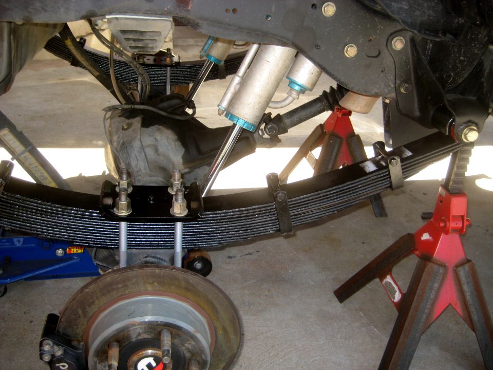 rear leaf springs, shocks, differential, and brake rotor on jack stands