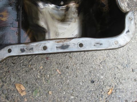 1981 Ford Bronco - Close-up of an oil pan, showing signs of use and dirt.