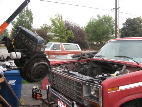 1981 Ford Bronco - Engine removal in progress on a red 1981 Ford Bronco, with another Bronco visible in the background.