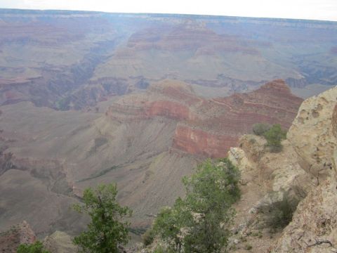 1991 Ford LTD Crown Victoria - A vast landscape of the Grand Canyon under a hazy sky, with rocky cliffs and distant mesas.