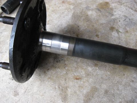 1994 Ford Bronco - Close-up of a rear axle shaft, showing wheel studs and a machined bearing surface.