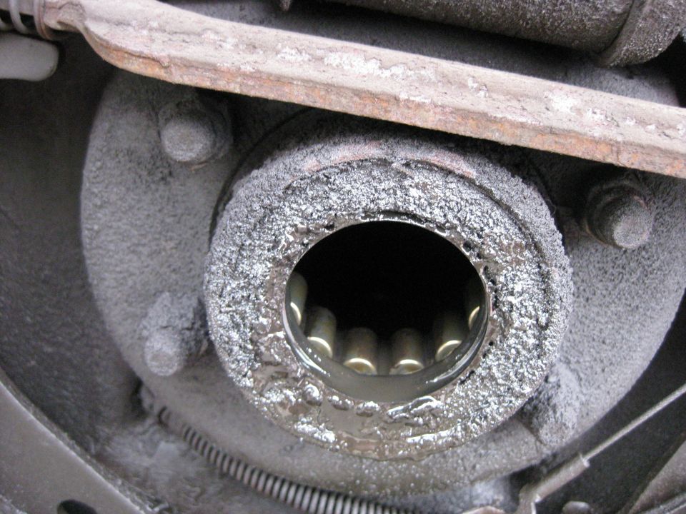 Rear axle hub with splines visible inside a greased opening. A metal bar is above