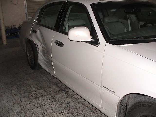 1999 Mercury Grand Marquis side view showing dented rear quarter panel