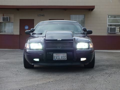 2003 Ford Crown Victoria - Headlights on, this modified Crown Victoria shows its push bar, billet grille and EVIL VIC plate head-on.