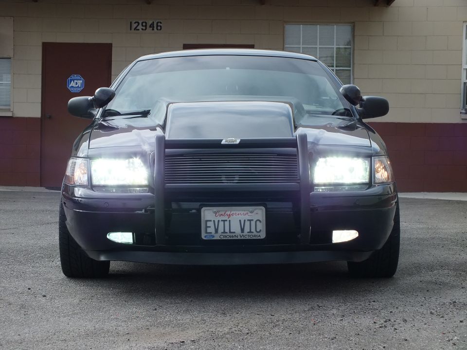 Black Ford Crown Victoria front end with billet grille, fog lights lit and EVIL VIC plate