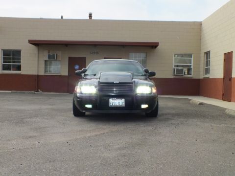 2003 Ford Crown Victoria - Lights blazing, the Crown Victoria sits centered in a wide parking lot near unit 12946.
