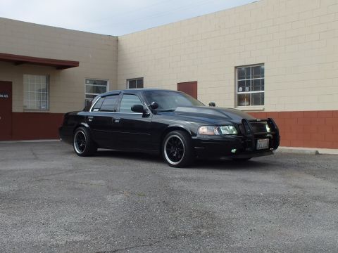 2003 Ford Crown Victoria - lowered Crown Victoria sits at an angle showing its push bar and dark tinted windows.