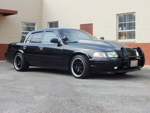 2003 Ford Crown Victoria - Sunlit angle of the Crown Victoria revealing body-side molding, push bar and California plate.