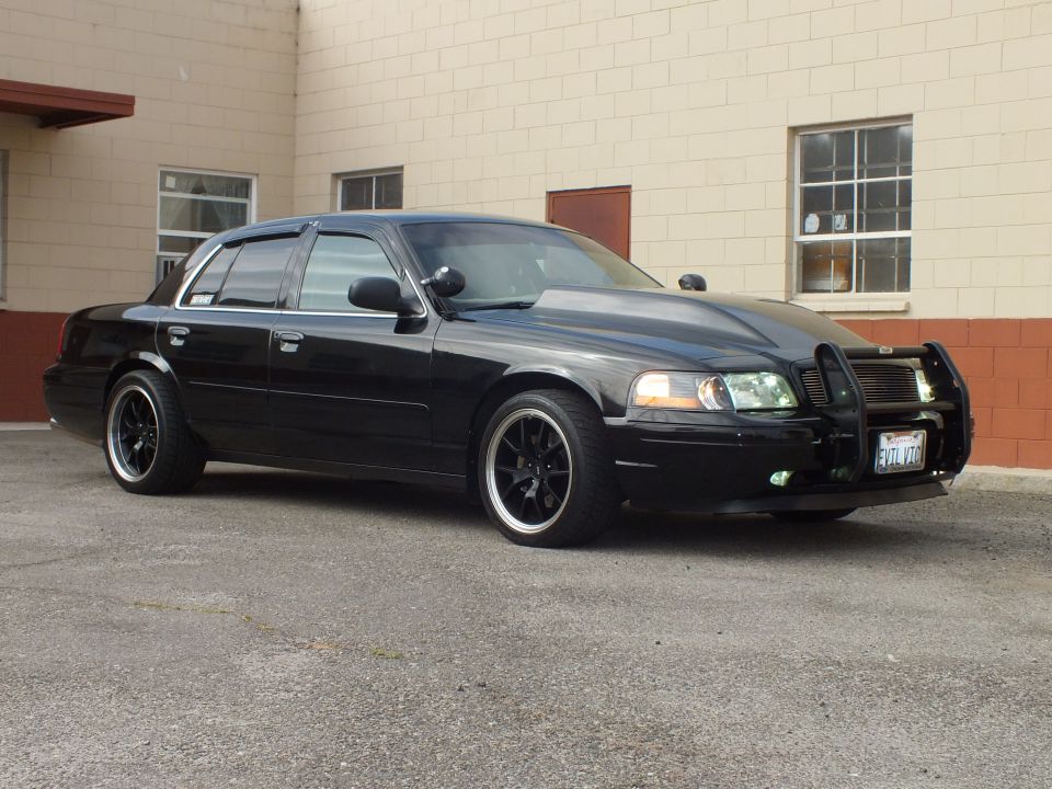 Black Crown Victoria front three-quarter with chrome trim, grille guard and black alloy wheels