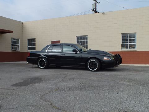 2003 Ford Crown Victoria - Full profile of the lowered Crown Victoria showing chrome window trim and front push bar.