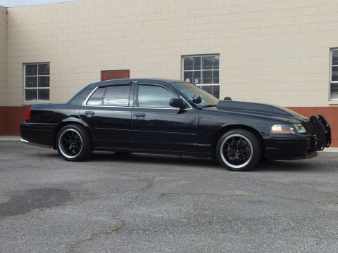 2003 Ford Crown Victoria - Crown Victoria shown in profile reveals its long sedan body and push-bar nose.