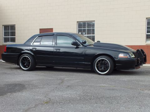 2003 Ford Crown Victoria - Profile shot of the dark Crown Victoria with chrome trim and front grille guard.