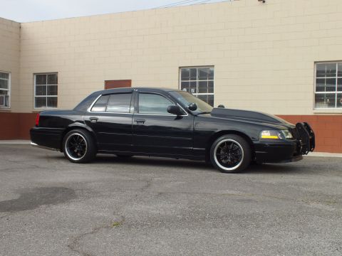 2003 Ford Crown Victoria - Right-side profile of the lowered Crown Victoria showing amber markers and front push bar.
