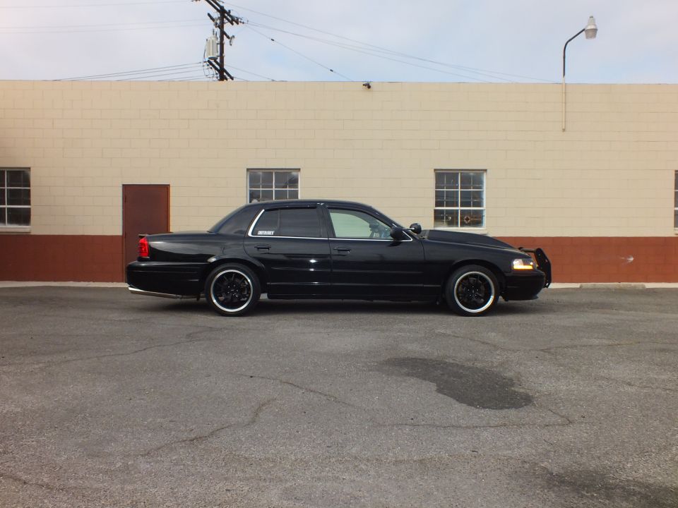 Black Ford Crown Victoria sedan, passenger side profile, lowered on black wheels