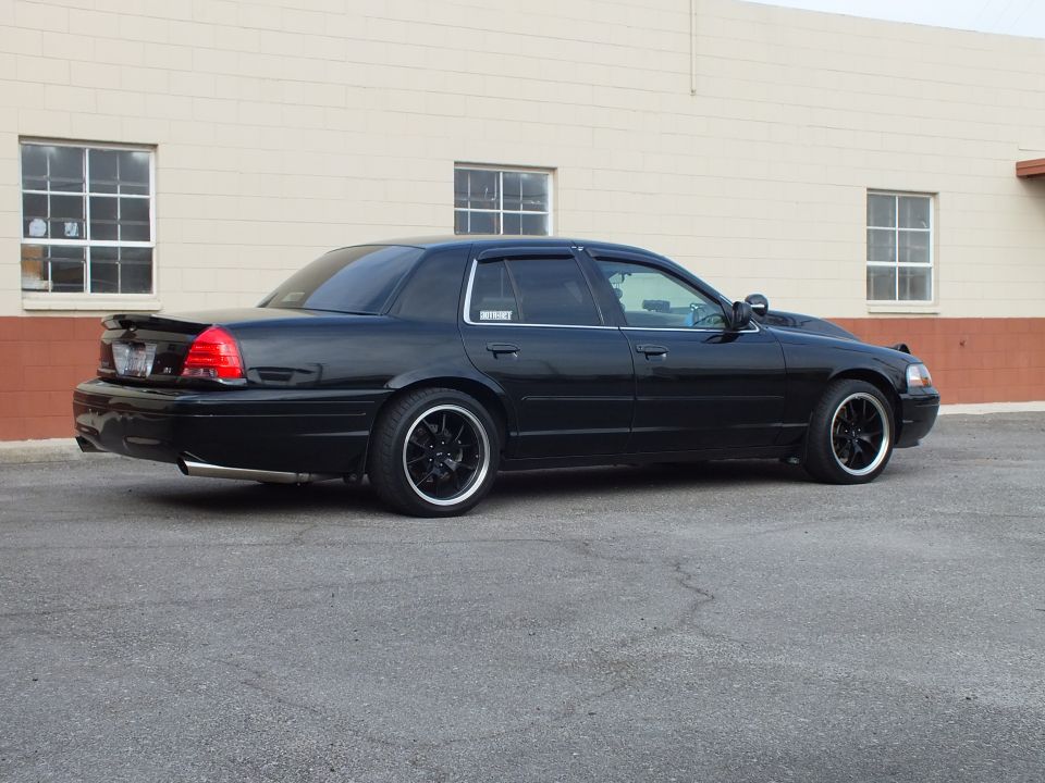 Black Ford Crown Victoria sedan, rear passenger side, lowered on black wheels