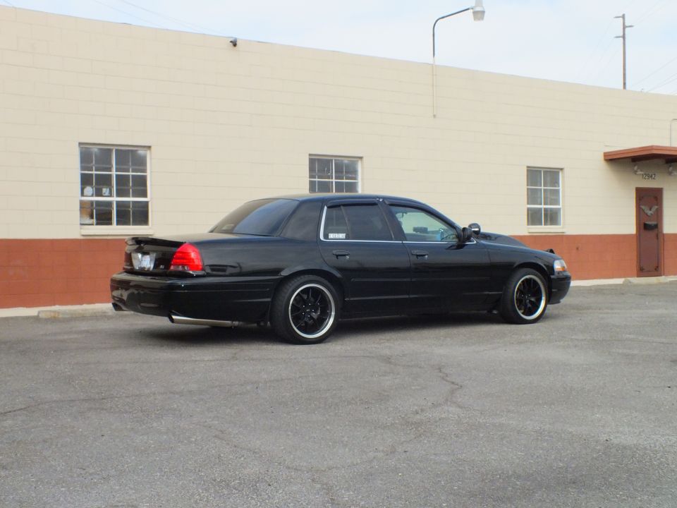 Black Ford Crown Victoria sedan, rear passenger three-quarter, lowered on black wheels