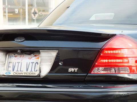 2003 Ford Crown Victoria - Tight detail of the trunk lid showing Ford oval, California EVIL VIC plate and SVT emblem.