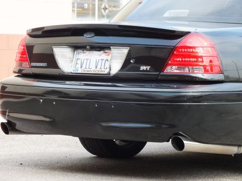 2003 Ford Crown Victoria - Close detail of black Crown Victoria trunk, SVT badge, Ford oval and EVIL VIC license plate