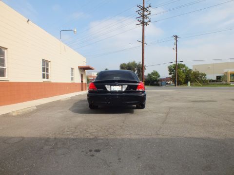 2003 Ford Crown Victoria - Black Crown Victoria parked rear-on in an empty asphalt lot under blue sky