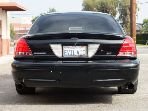 2003 Ford Crown Victoria - Tight rear shot of black Crown Victoria showing SVT badge, EVIL VIC plate, exhaust tips