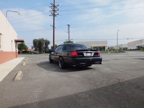 2003 Ford Crown Victoria - Lowered black Crown Victoria rear quarter parked beside an industrial building