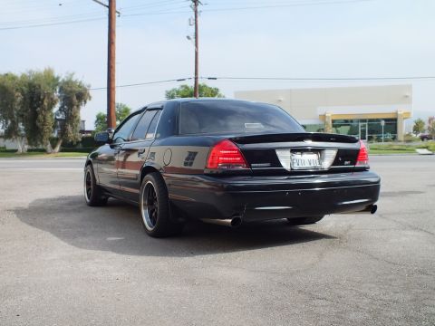 2003 Ford Crown Victoria - Left rear quarter of lowered black Crown Victoria on black wheels with side pinstriping