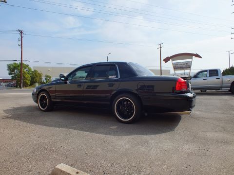2003 Ford Crown Victoria - Side profile of lowered black Crown Victoria sedan on black wheels in a parking lot