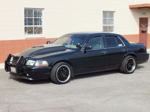 2003 Ford Crown Victoria - Front quarter view of black Crown Victoria with grille guard and black aftermarket wheels