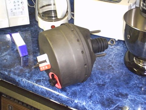 1991 Ford LTD Crown Victoria - A brake booster part sits on a blue speckled counter, with kitchen appliances in the background.
