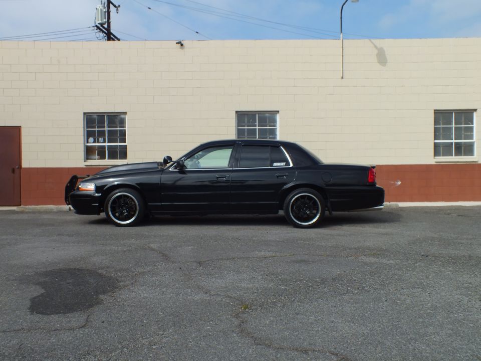 Black Ford Crown Victoria driver-side profile, push bar, black wheels, lowered