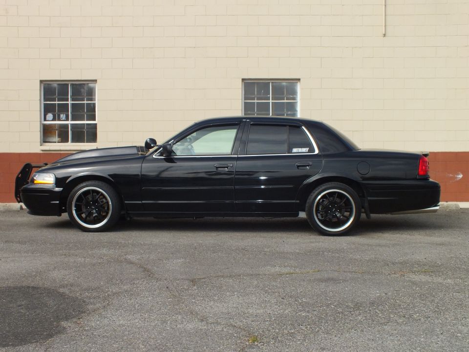 Black Ford Crown Victoria driver-side profile, push bar, vent visors, black wheels