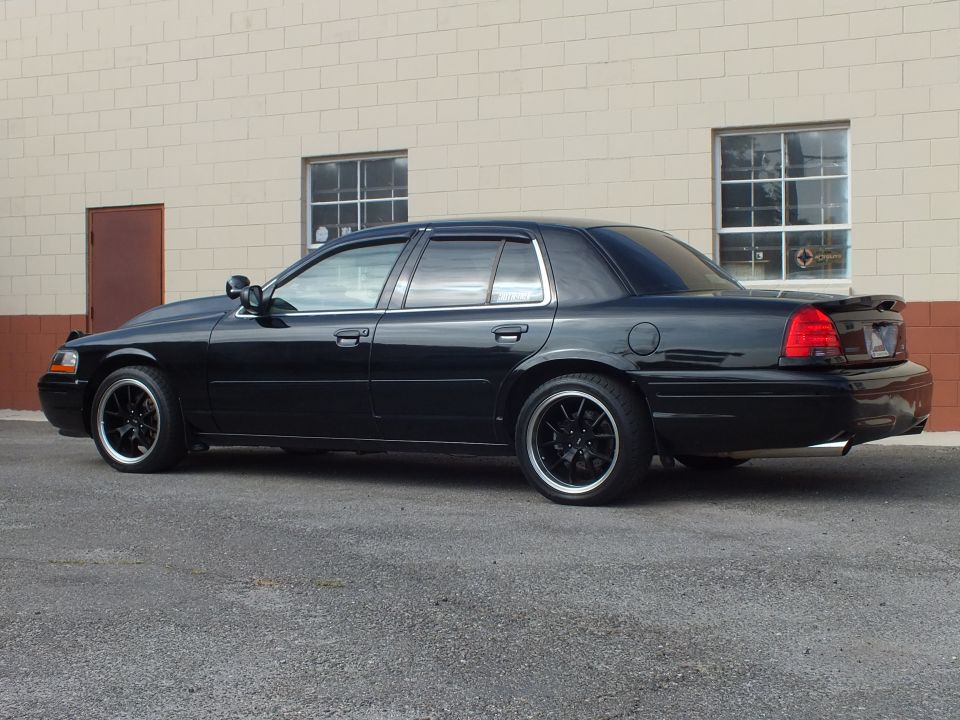 Black Ford Crown Victoria passenger-side rear three-quarter, vent visors, trunk spoiler