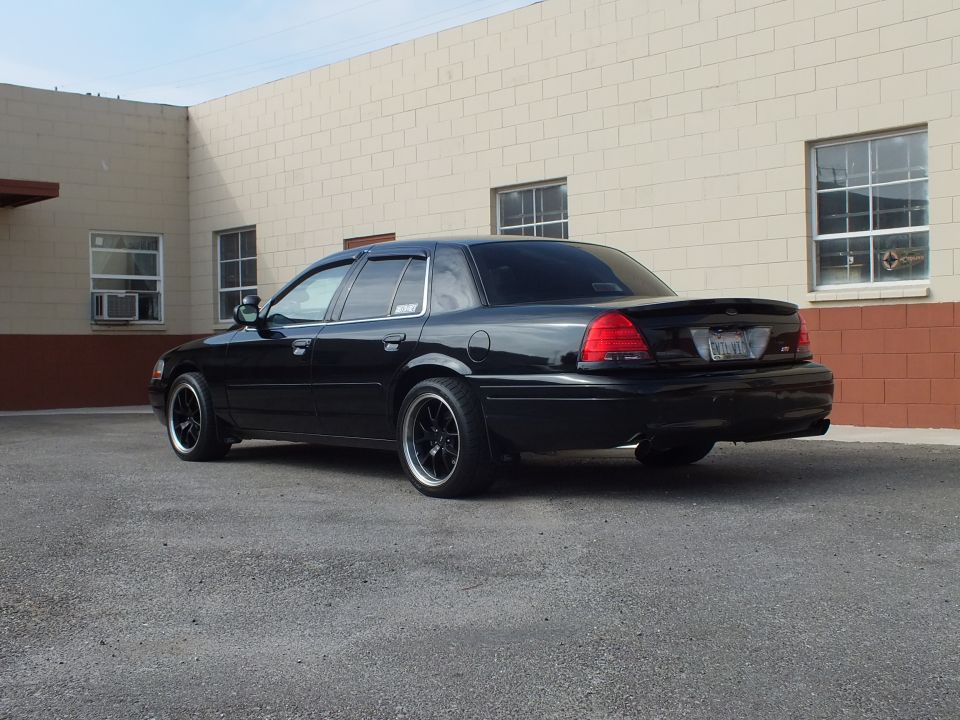 Black Ford Crown Victoria driver-side rear three-quarter, vent visors, lip spoiler