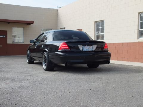 2003 Ford Crown Victoria - Rear of a black Crown Victoria with California EVIL VIC plate and SVT badge.