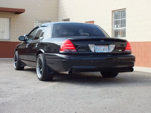2003 Ford Crown Victoria - Close rear shot of a black Crown Victoria, EVIL VIC plate and Ford oval visible.