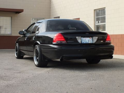 2003 Ford Crown Victoria - Rear of a murdered-out Crown Victoria, EVIL VIC plate and SVT badge in view.
