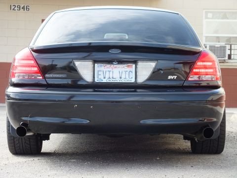 2003 Ford Crown Victoria - Symmetrical rear view of a black Crown Victoria SVT, Ford badge, dual exhaust, EVIL VIC plate.