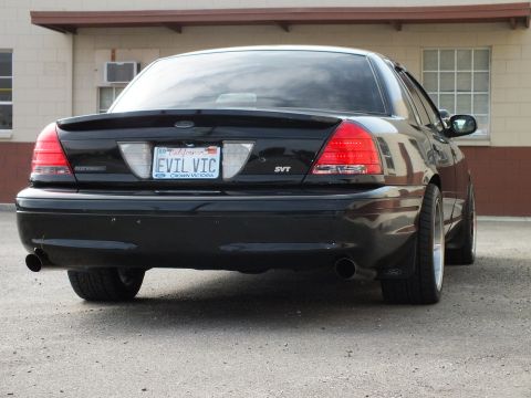 2003 Ford Crown Victoria - Rear angle of a black Crown Victoria SVT on chrome wheels with EVIL VIC California plate.