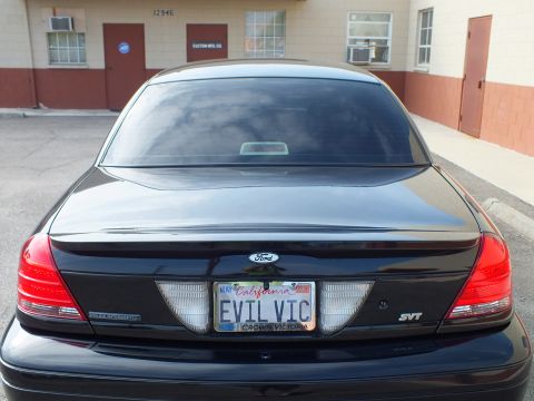 2003 Ford Crown Victoria - Overhead rear view of a black Crown Victoria trunk and heavily tinted rear glass, EVIL VIC plate.
